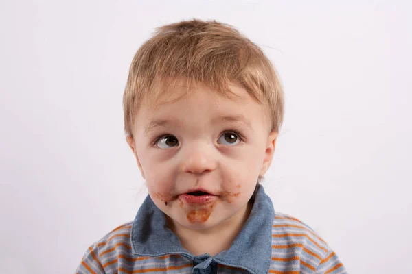 Portrati de un niño divertido con su cara de chocolate sucio — Foto de Stock