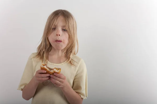 Roztomilá mladá dívka představí, nezdravé stravování s cheesebur — Stock fotografie