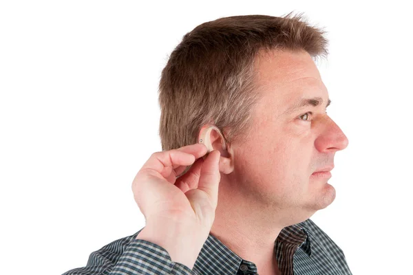 Hombre insertando un audífono en el oído — Foto de Stock