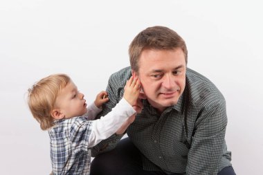 Yürümeye başlayan çocuk babasının işitme onun kulağına teftiş 