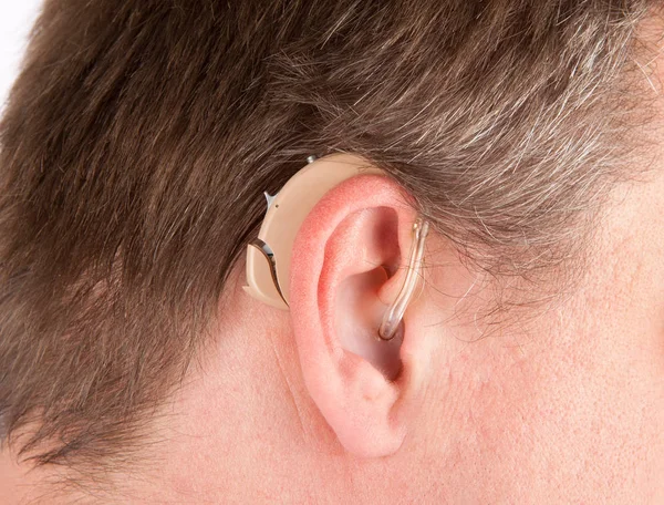 Γκρο πλαν του ένας ανώτερος άνθρωπος του αυτιού με ένα πίσω από-ο-αυτιά-ακρόαση dev — Φωτογραφία Αρχείου