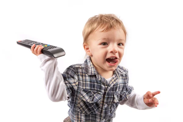 El niño gracioso tiene el control remoto de la TV. Aislado sobre blanco . — Foto de Stock