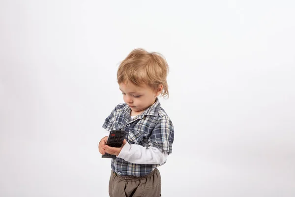 Imádnivaló kis fiú egy tv távirányító — Stock Fotó