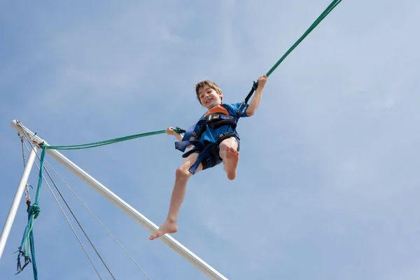 Joven chico disfrutando de saltar con trampolín saltar cuerda — Foto de Stock