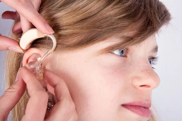Close up van een jong meisje hoofd en de audiologist het handen inse — Stockfoto