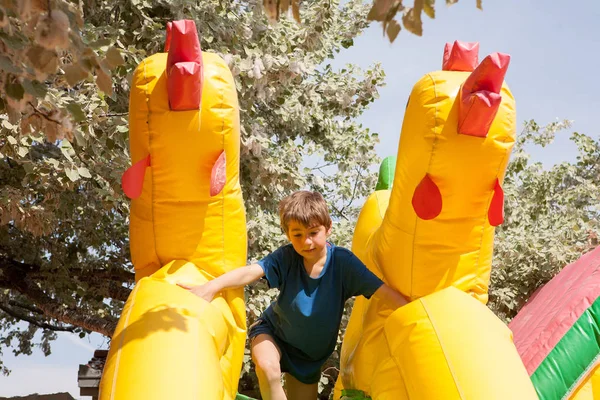 Jongen in een opblaasbare speelgoed huis in een park — Stockfoto