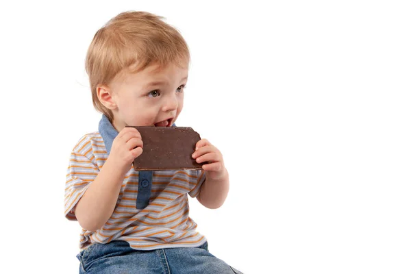 Adorable baby boy eating chocolate. — Stock Photo, Image