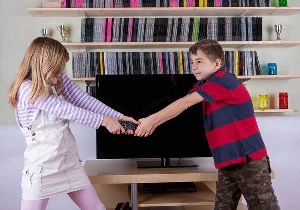 Broers en zussen die vechten voor de afstandsbediening voor de Tv — Stockfoto