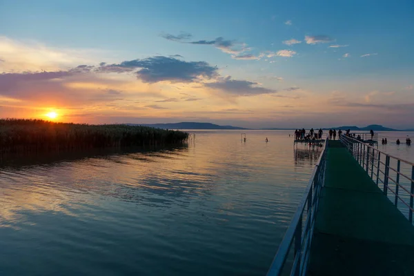 夕阳在巴拉顿湖与码头和在匈牙利中的剪影 — 图库照片