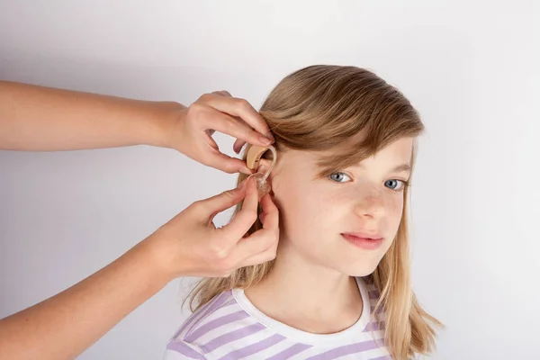Adorable girl trying a hearing aid — Stock Photo, Image