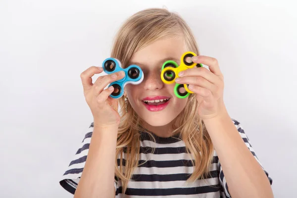 Menina engraçada brincando com quatro fidget spinners — Fotografia de Stock