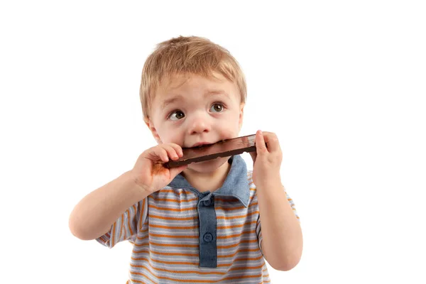 Retrato de un lindo niño comiendo chocolate. Aislado sobre blanco —  Fotos de Stock