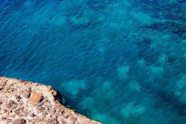 Sarı kırmızı şemsiye ve masmavi bir deniz ile plaj