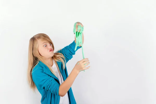 Schoolgirl playing with green slime looks like gunk — Stock Photo, Image