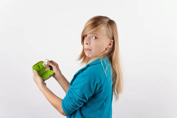 Menina segurando um aparelho auditivo e sua caixa expressando negatividade — Fotografia de Stock