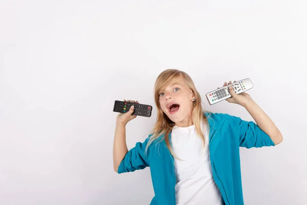 Chica alegre mostrando controles remotos — Foto de Stock