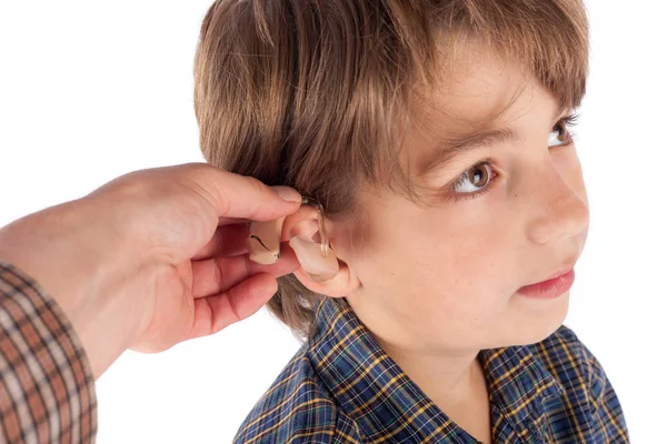 Close up of an Audiologist's hand fitting hearing aid to a young — Stock Photo, Image