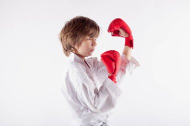 Karate kimono ve yetişmiş boks eldivenleri konsantrasyon giyen genç çocuk