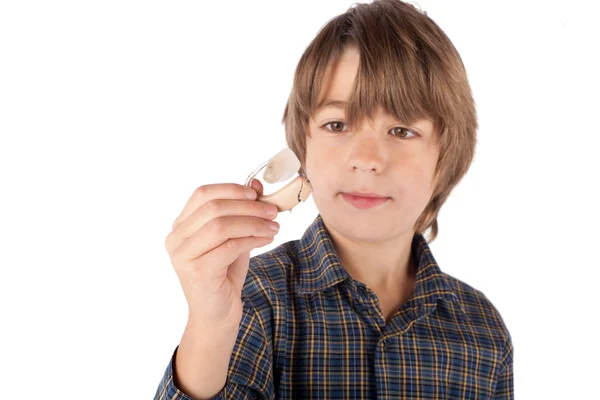 Schattige jonge jongen tonen van een gehoorapparaat. Geïsoleerd op witte CHTERGRO — Stockfoto