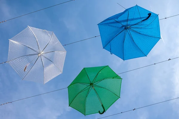 Street art with hanging blue, green and white umbrellas in Szent — Stock Photo, Image