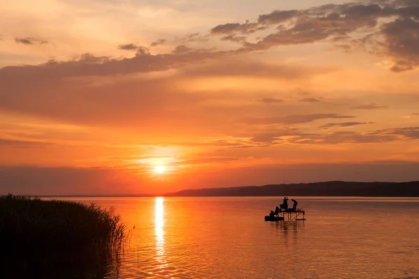 Beau coucher de soleil sur le lac Balaton avec des silhouettes de pêcheurs à la ligne a — Photo
