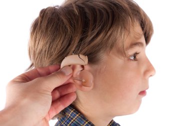 Doktor el genç bir çocuğun kulağına işitme cihazı ekleme. Isol