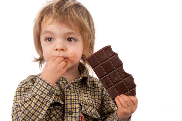 Adorável menino comendo chocolate — Fotografia de Stock