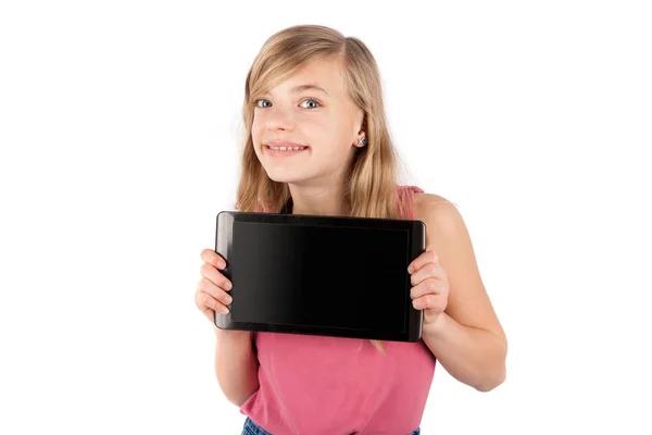 Pequeña colegiala sosteniendo un dispositivo de PC tableta con pantalla en blanco . — Foto de Stock