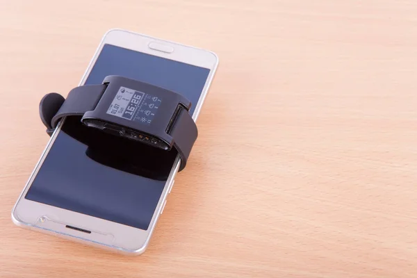 Smartphone and a smartwatch on an office table — Stock Photo, Image