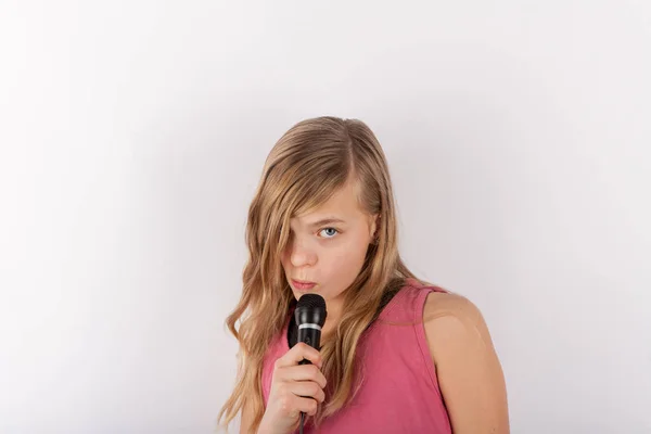 Молодая милая девушка с микрофоном, поющая караоке — стоковое фото