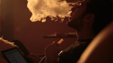 adam bir nargile içiyor ve tablet kullanır