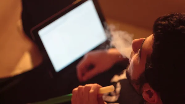 Ο άνθρωπος καπνίζει ναργιλέ και χρησιμοποιεί tablet — Φωτογραφία Αρχείου