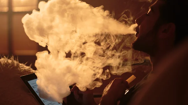 Hombre fuma una cachimba y utiliza la tableta — Foto de Stock