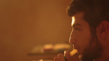 adam bir nargile sigara içiyor.