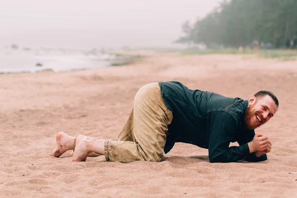 Happy bearded man crawling on all fours  the beach — Stock Photo, Image