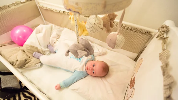 Baby lying in his cot — Stock Photo, Image