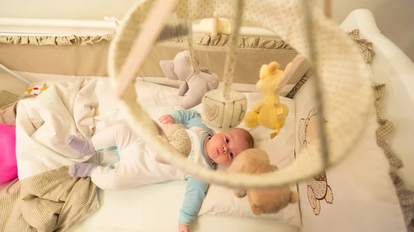 Baby lying in his cot