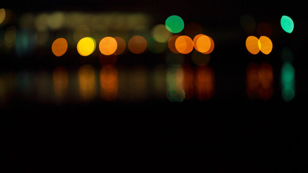 Beautiful night bokeh. Colorful abstract bokeh on a dark background. highlights the city at night reflected in water