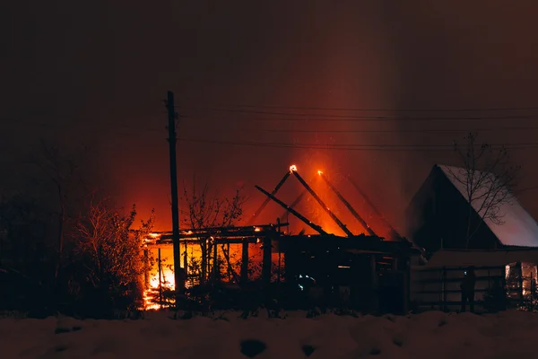 Požár v dřevěném domě v noci — Stock fotografie