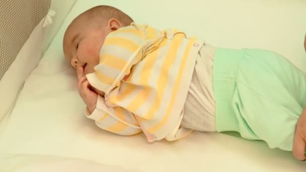 Little cute newborn baby is resting in his cot — Stock Video