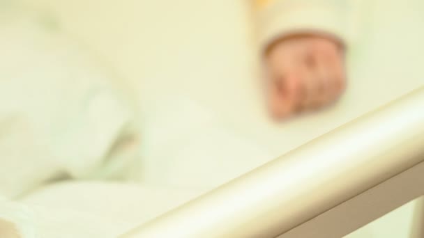 Маленький милый новорожденный ребенок отдыхает в своей кроватке — стоковое видео