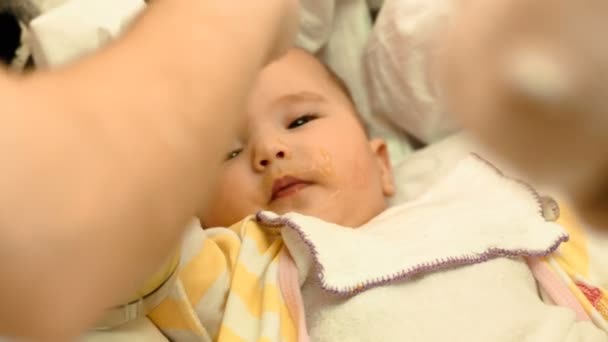 Moeder voedt met een lepel haar schattige pasgeboren baby puree van courgette — Stockvideo