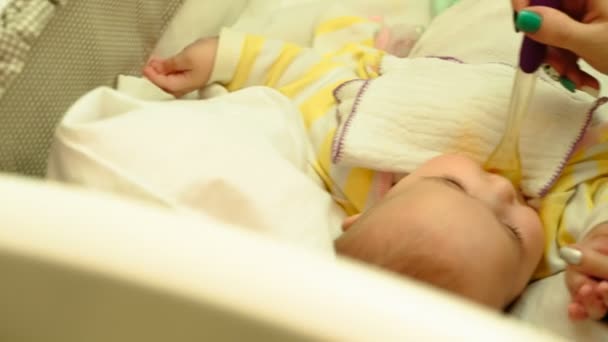 Mum feeds with a spoon her cute newborn baby puree of zucchini — Stock Video