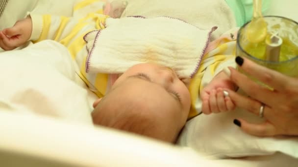 Mãe alimenta com uma colher seu bebê recém-nascido bonito purê de abobrinha — Vídeo de Stock