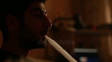 adam tek başına bir nargile sigara içiyor.