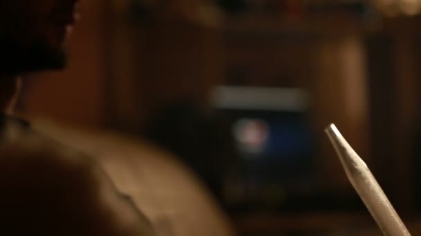 homme fume un narguilé seul 