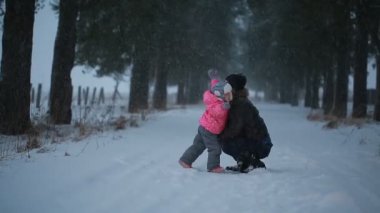 Baba ve kızı mutlu kış parkta sarılma
