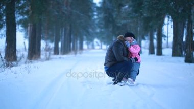 Baba ve kızı mutlu kış parkta sarılma