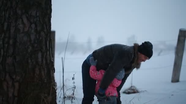 Pai joga as mãos em sua filha no parque de inverno — Vídeo de Stock