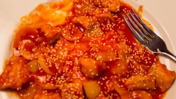 Курица в кисло-сладком соусе с кунжутом на тарелке — стоковое видео